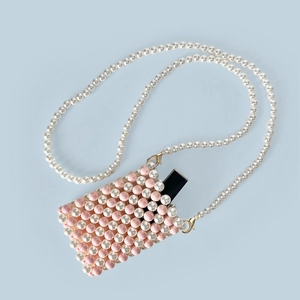 Detailed macro view of pink and white handmade beaded mini pearl crossbody bag for lipstick