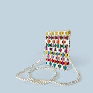 Detail of colorful wooden beads and pearl strap on a mini handmade crossbody bag