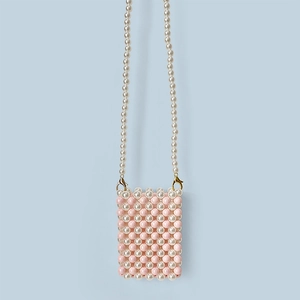 Detail of pink and white faux pearl woven crossbody bag with golden lobster clasp