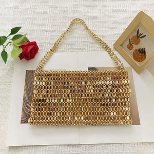 Close-up of golden beaded handbag with metallic scale texture and hand-woven design