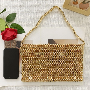 Detail of handmade gold sequin woven handbag with beaded chain strap and shiny metallic finish