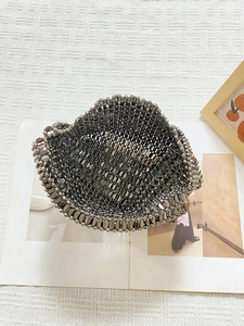 Detailed view of silver metallic bead weave bag with reflective oval and round beads