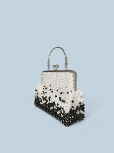 Detail of beaded evening bag with black and white gradient and ornate silver metal handle