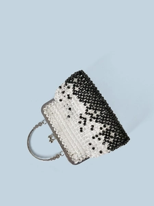 Close-up of black and white beaded handbag with vintage silver metal ring handle