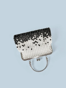 Detail of beaded evening bag with silver engraved handle and spherical kiss lock closure