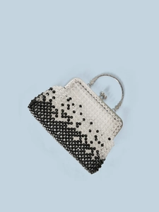 Detail of silver embossed handle and black and white beaded texture of a handmade evening bag