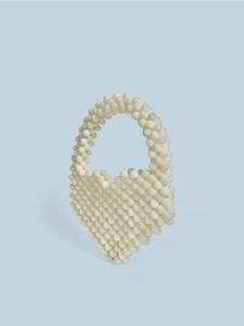 Detail of a handmade heart-shaped beaded handbag in creamy white with pearl-like texture