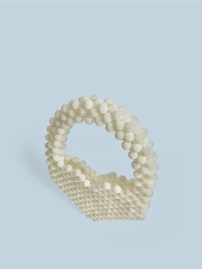 Detailed view of handmade beige beaded handbag featuring a unique spherical texture