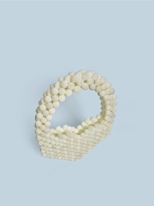 Detailed view of handmade beaded tote bag with pearl-like texture and round handle