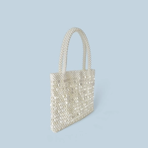 Detailed view of hand-woven beaded pearl handbag featuring shimmering white sequin textures