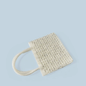 Detail of a handmade white pearl beaded handbag with a structured square design