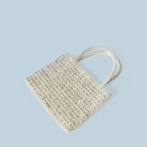 Detail of hand-woven white pearl beaded handbag with vintage hollow square structure