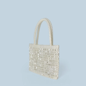 Close-up of white beaded sequin handbag with pearl handles in vintage luxury style