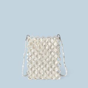 Dettaglio borsa a tracolla in perle bianche con trama floreale e fodera in raso bianco