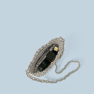Dettaglio interno della borsa di perle argento con spazio per cosmetici e rossetti