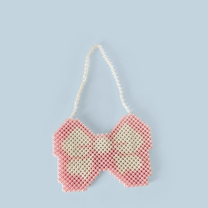 Close-up of pink and white handmade beaded bag featuring a unique butterfly bow design