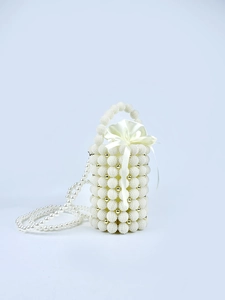 Detail of handmade pearl bead bucket bag with gold accents and satin drawstring bow closure
