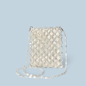 Dettaglio borsa di perle intrecciate a mano con paillettes argento e fodera in raso