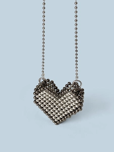 Dettaglio macro della mini borsa di perline a forma di cuore con texture metallica