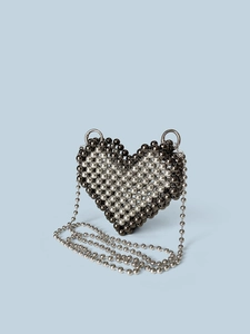 Dettaglio borsa a tracolla a forma di cuore con perline d'argento su fondo blu