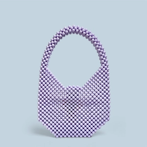 Detailed weave pattern of a lavender acrylic beaded handmade shoulder bag with round handle