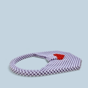 Detail of handmade lavender beaded handbag with contrast red heart pattern detail