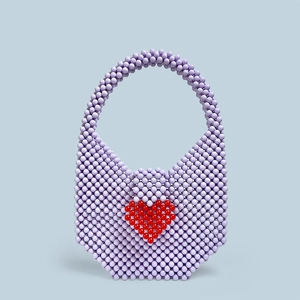 Detail of lavender beaded handbag featuring a red heart pattern and round acrylic beads