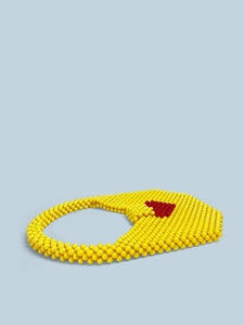Detailed macro view of yellow beaded handbag featuring a red heart motif and intricate handwork