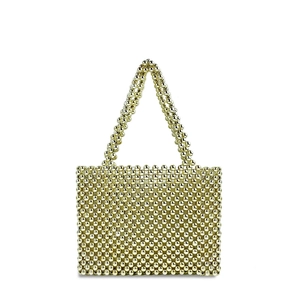 Detail of hand-woven gold metallic beads and pearl-style texture on a fashion tote bag