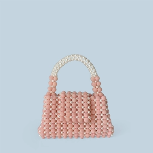 Detail of hand-woven pink and white pearl beaded handbag with vintage textured finish