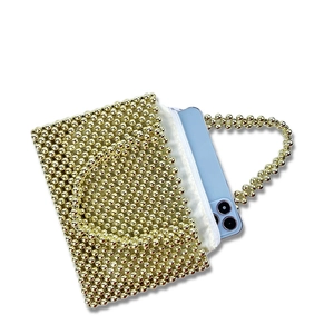 Detail of handmade gold beaded bag showing interior space with a smartphone inside