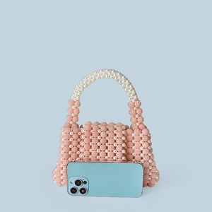 Detailed macro view of handmade pink and white beaded texture on a mini handbag