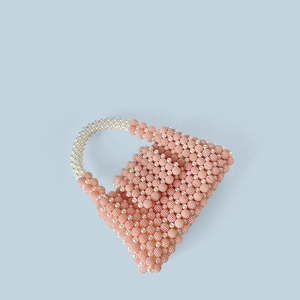 Detail of pink and cream beaded pattern and handmade weave on the fashion mini handbag