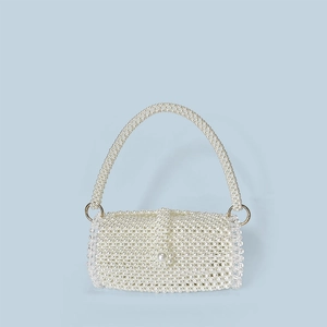 Detailed view of handmade woven pearl evening bag with large decorative pearl closure