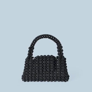 Detailed view of handmade black beaded handbag with shiny texture and woven trapezoid shape