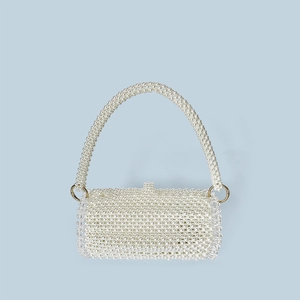 Detail of hand-woven pearl bag with golden metal rings and elegant clasp texture