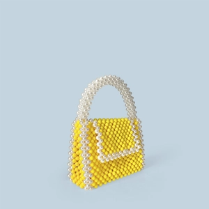Close-up of a handmade beaded handbag featuring yellow and cream pearls in a woven texture
