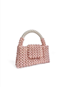 Detail of pink beaded handbag with white faux pearl embellishments and top handle