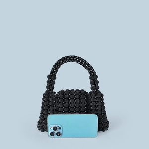 Close-up of handmade black beaded handbag showing intricate texture and mini size structure