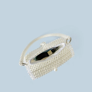 Detail view of pearl beaded evening bag showing capacity with a smartphone inside
