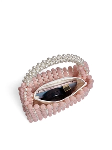 Detail view of pink beaded handbag showing white pearl handle and spacious interior