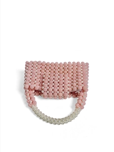 Detail of pink beaded handbag with lustrous large white pearl handle on white background