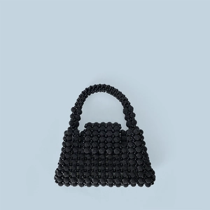 Macro view of handcrafted black beaded texture on a minimalist retro style handbag