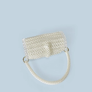 Close-up of white faux pearl beaded handbag with elegant golden metal ring attachment