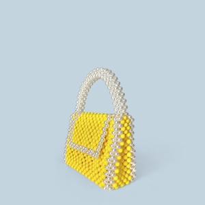 Detail of yellow beaded handbag with pearl accents and hand-woven square box structure