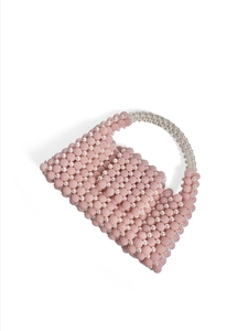 Detailed view of pink and white handcrafted beaded handbag with faux pearls and curved handle