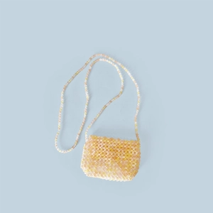 Detailansicht der handgefertigten mehrfarbigen Perlen-Mini-Tasche auf blauem Hintergrund