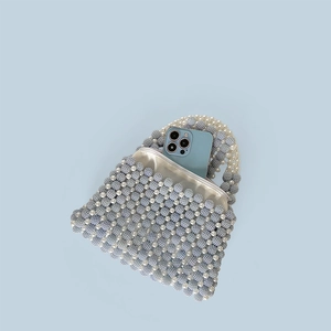 Detail of handmade beaded handbag showing blue and white pearls with satin lining