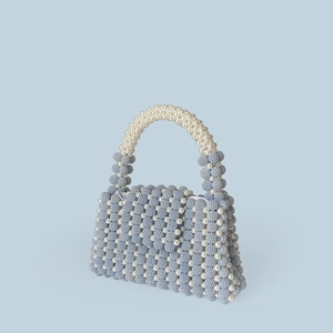 Detail view of handmade light blue and white pearl beaded handbag with striped pattern
