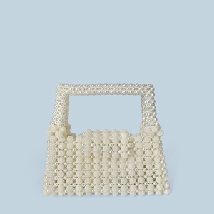 Close-up of handmade white pearl beaded handbag with woven texture and square flap